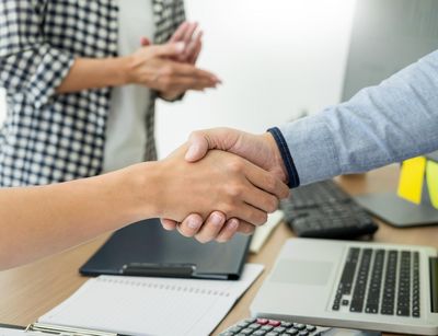Zwei Menschen geben sich die Hand